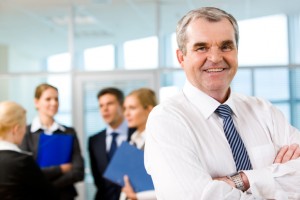 Image of senior leader smiling at camera in working environment